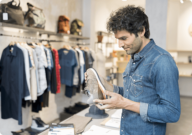 aumento-da-retanbilidade Representação de atendimento em loja. Homem segurando um sapato dentro de uma loja.
